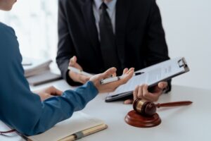 Close-up of legal documents, a gavel, and attorneys discussing case details in a professional setting.