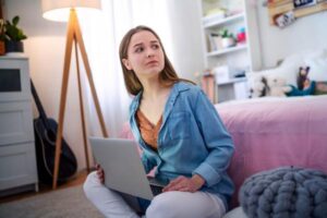 Worried young girl with laptop sitting