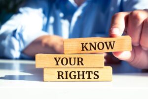 Wooden blocks arranged to spell out the words 'KNOW YOUR RIGHTS'.