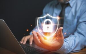 Businessman holding a lock with a shield, symbolizing the protection of personal data and privacy in technology and business.