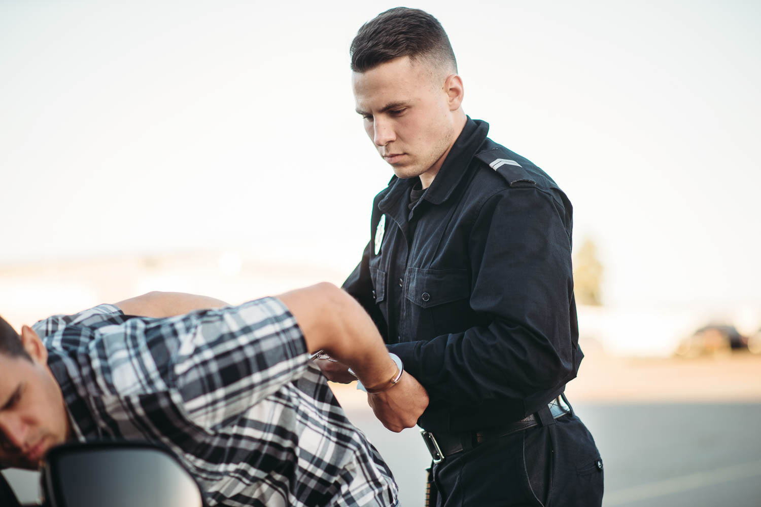 Policeman arrests the car thief on road. Cop at the work. Law protection concept, professional safety control