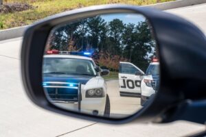 Two police vehicles conducting a routine traffic stop on a sedan, with officers interacting with the driver