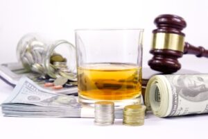 The visual representation of the drink driving concept, incorporating a judge's gavel, a whiskey glass, and car keys to symbolize legal consequences and responsibility.